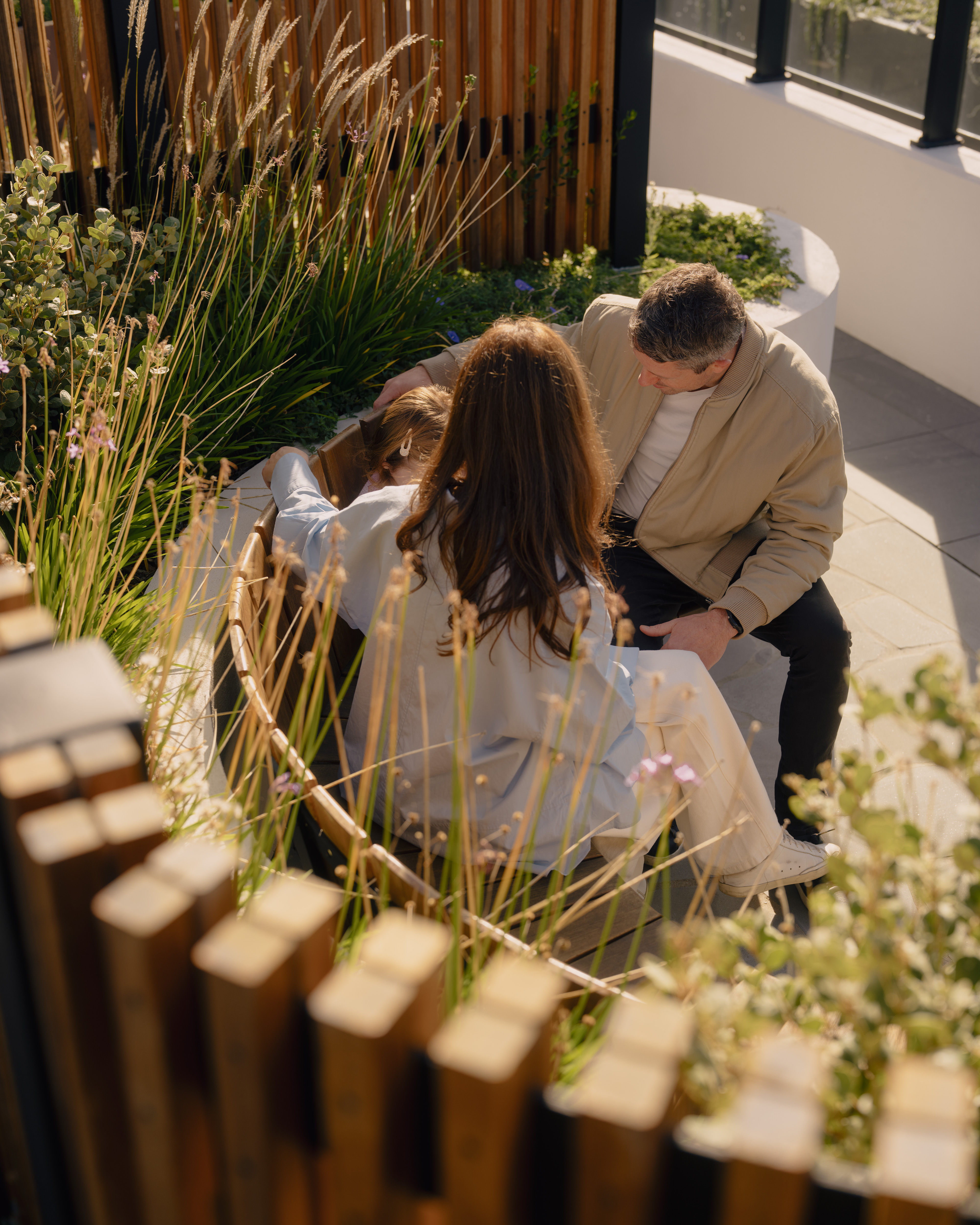 Family sitting together in a landcsaped space